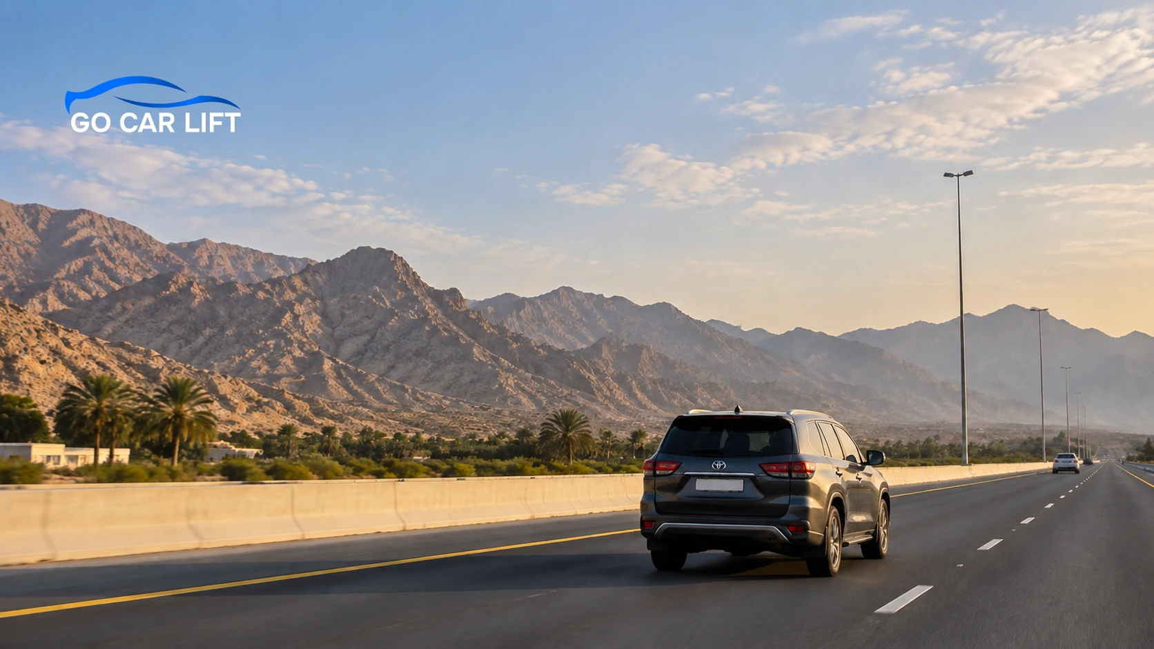 SUV driving on highway past scenic mountains for Car Lift Dubai to Ras Al Khaimah.