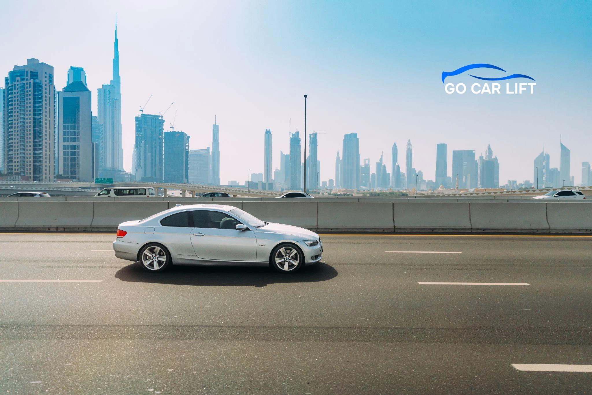 Silver sedan driving on highway with skyline view for Car Lift Services in Dubai.